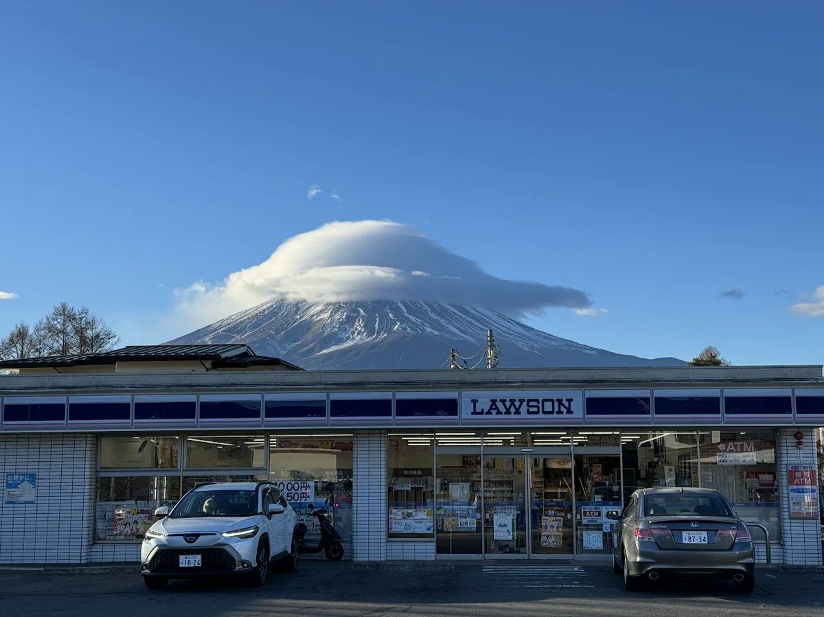 가와구치코 로손 편의점 뒤로 구름 덮인 웅장한 후지산 전경