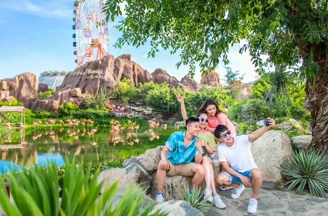 대관람차와 홍학 정원을 배경으로 사진을 찍는 방문객들