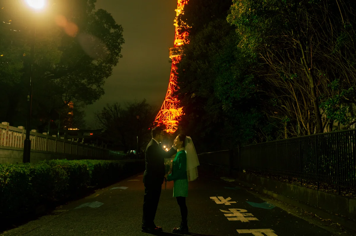 도쿄타워 야경을 배경으로 마주 서 있는 신랑 신부의 모습