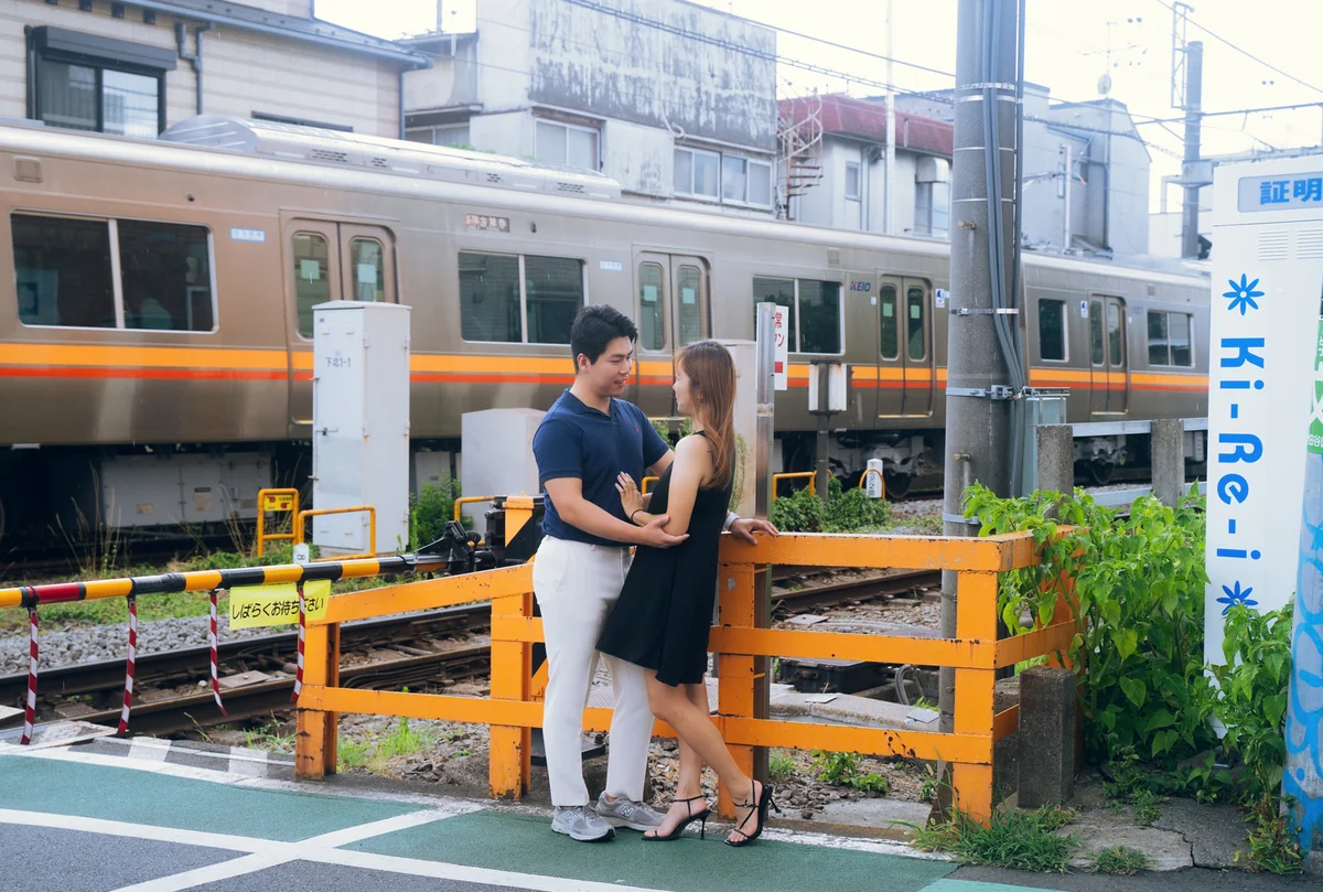 도쿄 기찻길 건널목에서 서로를 바라보는 연인의 모습