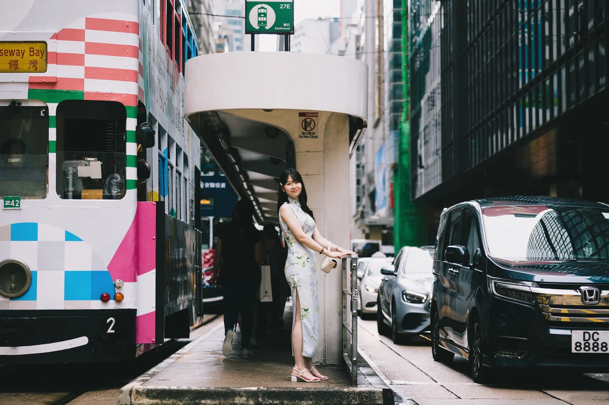 홍콩 도심 전차 승강장에 서 있는 치파오 차림의 여성